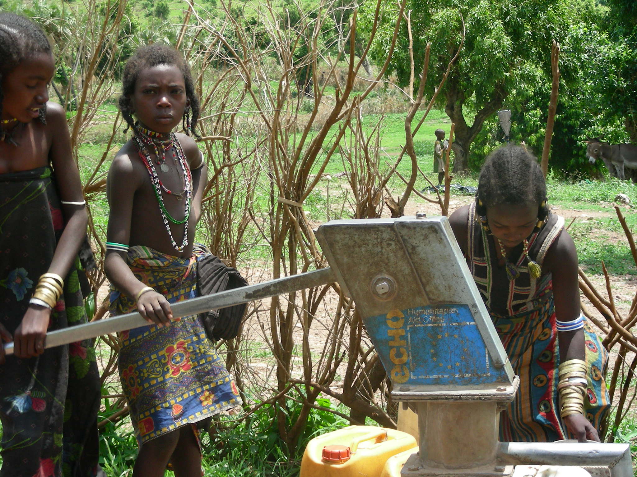 People collecting water at a handpump